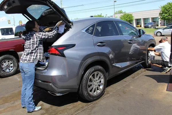 A Hamilton Place team member hand-wiping an SUV during a detail